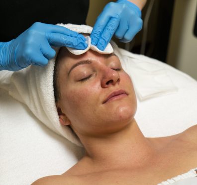 Face massage prepare at spa salon. Doctor hands. Pretty female patient. Beauty treatment. Healthy skin procedure. Young woman head. Cleaning rejuvenation. Facial dermatology mask. Detox therapy